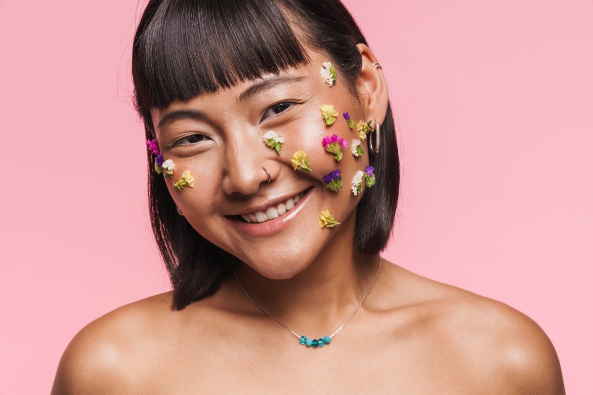 Woman with bright, even skin and flowers